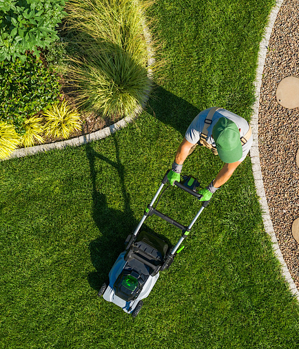 Gardener Mowing Backyard Garden Grass Aerial View. Lawncare service stoke on Trent